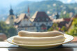 White sausages on a plate on a restaurant table outdoors with a typical Bavarian town in the background