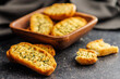 Garlic crisp bread Slices Topped With Herbs on black table.