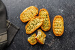 Garlic crisp bread Slices Topped With Herbs on black table. Top view.