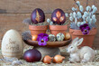 Ostereier mit Blattmuster gefärbt mit Zwiebelschalen in Terracotta-Töpfen und Osterhase als Oster-Arrangement