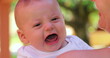 © Marco - Infant newborn baby changing emotions outdoors held by mom