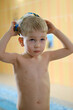 © ninelutsk - Happy cute toddler child near the pool side smiling in goggles after swimming lesson indoor. Physical development and healthy water activities for kids