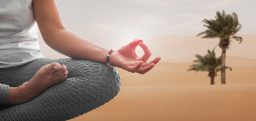 Wall Mural - Woman meditating in yoga position with desert background