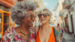 Happy trendy multiracial women having fun together outdoor - Joyful senior female friends hugging each other in the city during summer time