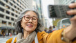 Happy trendy senior asian woman taking a selfie in the city during travel vacation - Holiday concept - Models by AI generative