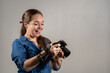 Mujer fotógrafa contenta revisando la pantalla de su cámara reflex	