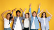 © Prostock-studio - Five multiethnic teenagers stand side by side against a vibrant yellow backdrop, smiling and posing with their hands. Two of them are creating heart shapes above their heads