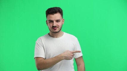 Wall Mural - A man, close-up, on a green background, points to the side