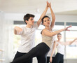 © JackF - Focused graceful couple of ballet dancers showcasing skillful supports during group class in light-filled choreography studio