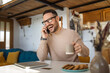 © Miljan Živković - Adult caucasian man prepare for breakfast and talk on mobile phone