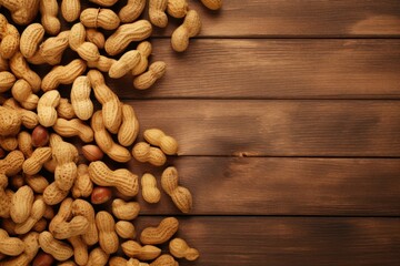 Top view of unshelled peanuts loosely spread over a richly textured wooden background