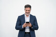 © Stock 4 You - Smiling Latin business man using smartphone mobile phone screen device, scrolling app, working for communication with partners. Mature businessman in suit holding cellphone isolated, white background