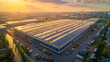 A large industrial warehouse roof covered with solar panels gleams under a golden sunset sky, emphasizing sustainability.