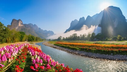 Canvas Print - panorama of tall rocky mountains covered in white smoke under the mountain flowing clear and fresh rivers on the banks of the river there are many colorful flowers light sun morning generate ai