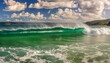 surfing waves with an emerald hue roll energetically beneath a sky adorned with fluffy clouds creating a captivating and vibrant coastal scene