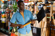 Portrait of african american man choosing shovel in gardening market