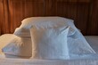 Hotel bed with white sheets, cozy lighting