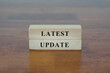 Latest Update message sign on a wooden desk.