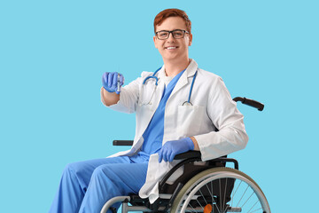 Poster - Male doctor in wheelchair with injection on blue background