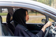 Closeup a beautiful Asian Muslim woman wearing traditional clothes driving a car in city