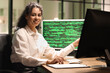 © Pixel-Shot - Female African-American programmer sitting in office at night