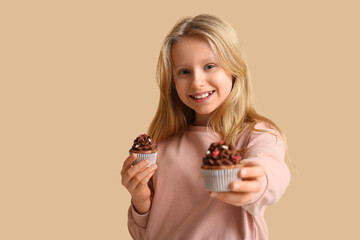 Wall Mural - Cute little girl with tasty cupcakes on color background