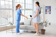 © Pixel-Shot - Young pregnant woman visiting doctor in clinic