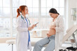 © Pixel-Shot - Young pregnant woman visiting doctor in clinic