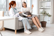 © Pixel-Shot - Female doctor talking to pregnant woman on sofa in clinic
