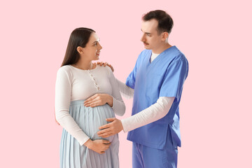 Sticker - Male doctor hugging pregnant woman on pink background