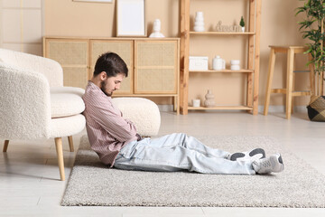 Canvas Print - Tired young man sleeping on floor at home