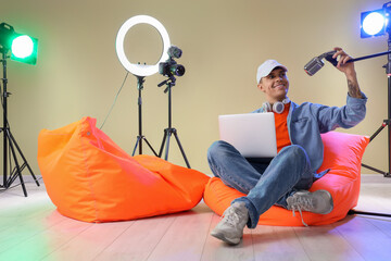 Poster - Young man with laptop and microphone recording podcast in studio