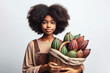 Young afro girl carrying a basket full of cacao pods on her head on white background