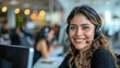 © Hryhor Denys - A Hispanic woman with a joyful expression, wearing a black headset, looks directly at the camera