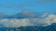 Heavily Snow Covered Mountains. Snowy Peaks Under Blue Skies And Moving Clouds. Timelapse.