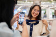 A woman taking a picture of her friend with a new clothe, having a fun shopping day together.