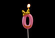 Burning pink birthday candle with golden bow isolated on black background, number 0.	