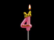 Burning pink birthday candle with golden bow isolated on black background, number 4.	