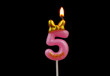 Burning pink birthday candle with golden bow isolated on black background, number 5.	