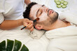 Skincare, face mask and man in spa with relax for vegan beauty, skin glow and dermatology therapy. Male client, facial and hands of masseuse in salon for acne, natural cosmetics and luxury aesthetic