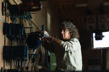 Wall Mural - Mature carpenter taking tool for work