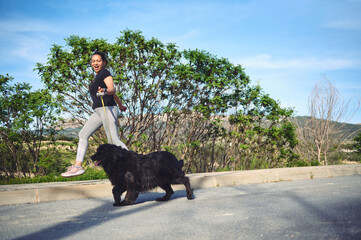 Wall Mural - I'm jogging with my pet outdoors. Cheerful happy woman enjoying her morning run with her cocker spaniel dog being walked on leash on the nature. People. Playing pets. Healthy active lifestyle concept