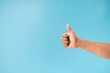 Thump up hand sign isolated on blue background.