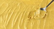 Yellow mustard sauce with metal spoon, spread background and texture, top view