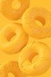 Chocolate glazed donut with sprinkles on plain monochrome yellow color