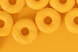 Isometric view of glazed donut with sprinkles on plain monochrome yellow color