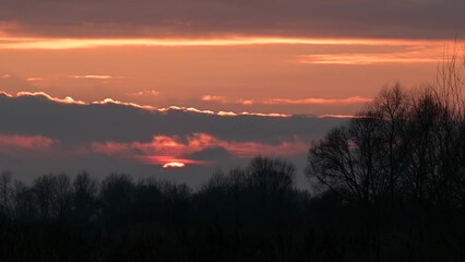 Sticker - Sun setting on the horizon. Autumn video of sunset with bright colorful clouds