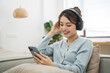 © Q88 - Portrait of Asian woman sitting on sofa at home