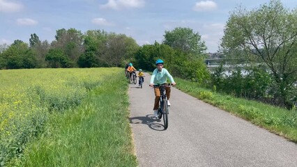 Poster - Happy family, children boys and adults, riding bikes together on a summer sunny day