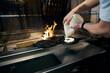 Cropped male chef pouring dough on pancake maker at burning fire place